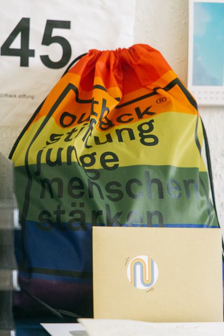 Unterstützung für LSBTI* Kinder, Jugendliche und ihre Familien Beutel in Regenbogenfarben und dem Outback-Logo