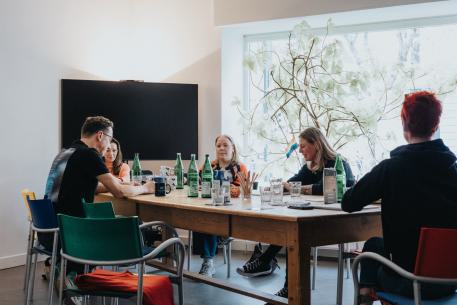 Verselbstständigung für Jugendliche es sitzen fünf Personen an einem Tisch und beraten sich