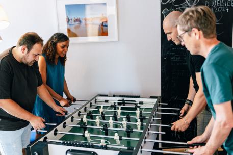 Familienhilfe vier Menschen spielen zusammen Kicker Familienhilfe vier Menschen spielen zusammen Kicker