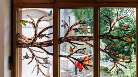 Pflegefamilien Fenster mit aufgemaltem Ast und Blüten